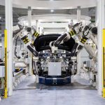 Robôs industriais montam um veículo em uma linha de produção automotiva moderna.