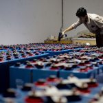Trabalhador inspeciona conjuntos de baterias industriais em uma instalação de armazenamento de energia.