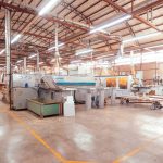Interior de uma fábrica em Pato Branco, com máquinas industriais organizadas em uma ampla linha de produção