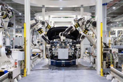 Robôs industriais montam um veículo em uma linha de produção automotiva moderna.