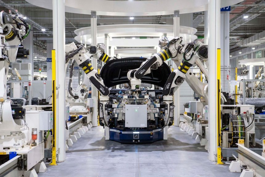Robôs industriais montam um veículo em uma linha de produção automotiva moderna.