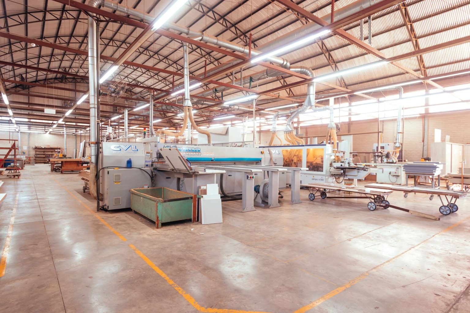 Interior organizado de uma fábrica brasileira, com máquinas industriais e área de produção.